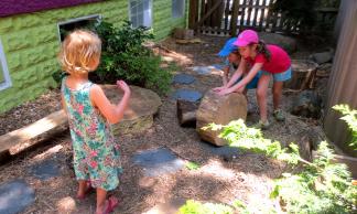 Photo by Lesley Romanoff, Takoma Park Cooperative Nursery School Children move a stump to another part of the yard.